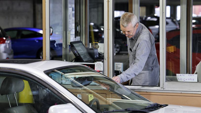 Kevin Johnston works the exit gate at the Butler County Government Services Center parking garage Thursday, Jan. 6, 2022 in Hamilton. Butler County Commissioners have awarded a $200,000 contract to fully automate the garage. NICK GRAHAM / STAFF