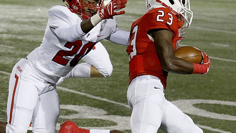Fairfield’s Allen Caldwell (20) tries to make a tackle on Colerain’s J.J. Davis (23) during last Friday night’s game at Cardinal Stadium in Colerain Township. The host Cardinals won 55-27. CONTRIBUTED PHOTO BY E.L. HUBBARD