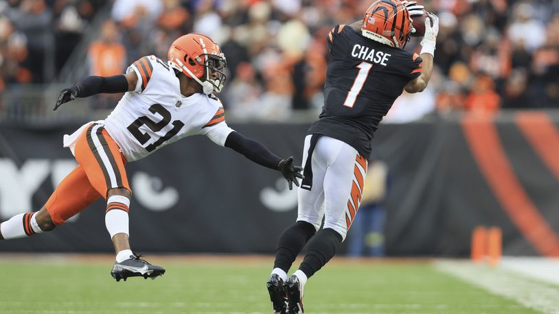 Cincinnati Bengals' Ja'Marr Chase (1) makes a catch against Cleveland Browns' Denzel Ward (21) during the second half of an NFL football game, Sunday, Dec. 11, 2022, in Cincinnati. (AP Photo/Aaron Doster)