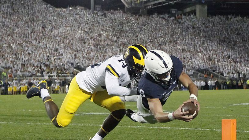 Penn State quarterback Trace McSorley (9) dives for a touchdown as Michigan’s Josh Metellus (14) defends during the second half in State College, Pa., Saturday, Oct. 21, 2017. Penn State won 42-13. (AP Photo/Chris Knight)