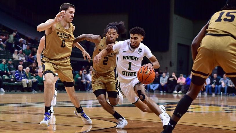 Wright State's Trey Calvin drives past Purdue Fort Wayne's Bobby Planutis (0) and Damian Qui Chong at the Nutter Center on Jan. 19, 2023. Joe Craven/Wright State Athletics