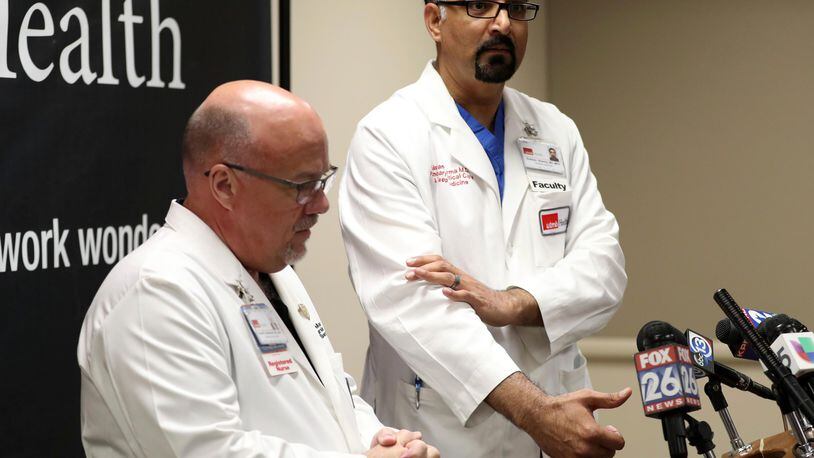 Chief Nursing Officer Dr. David Marshall, left, and Chief Medical and Clinical Officer Dr. Gulshan Sharma, who gestures around the area where Santa Fe Independent School District police officer John Barnes was shot, speak to the media at Jennie Sealy Hospital at the University of Texas Medical Branch in Galveston, Texas.