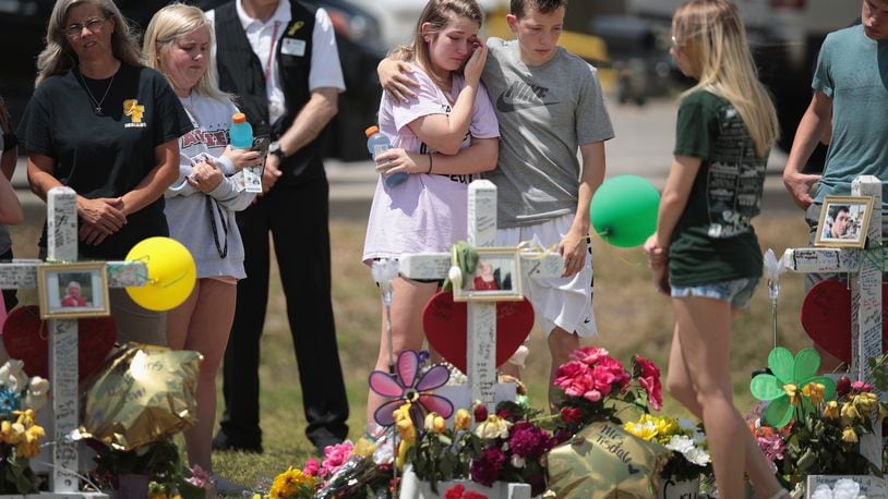Mourners visit a memorial in front of Santa Fe High School on May 22, 2018 in Santa Fe, Texas. The makeshift memorial honors the victims of last Friday’s shooting when 17-year-old student Dimitrios Pagourtzis entered the school with a shotgun and a pistol and opened fire, killing 10 people. (Photo by Scott Olson/Getty Images)