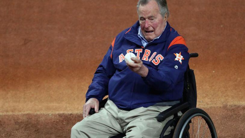 George H.W. Bush examines the baseball before Game 5 of the 2017 World Series at Minute Maid Park in Houston.