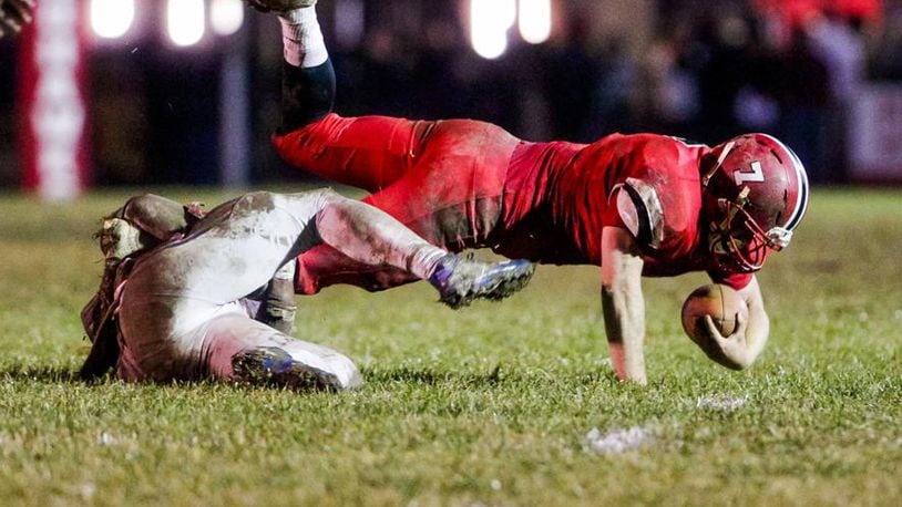 Madison quarterback Mason Whiteman fights for every extra yard Saturday night during the Mohawks’ 26-0 victory over Portsmouth in a Division V, Region 20 playoff game at Brandenburg Field in Madison Township. NICK GRAHAM/STAFF