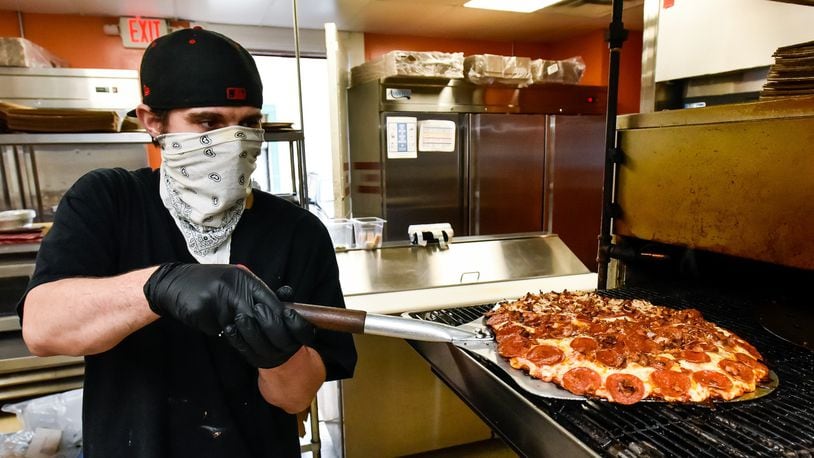 Jonathon Turner makes a pizza at Don’s Pizza on Central Avenue Wednesday, April 29 in Middletown. Don’s Pizza is open for carryout and delivery while the dining room is closed due to coronavirus pandemic. NICK GRAHAM/STAFF