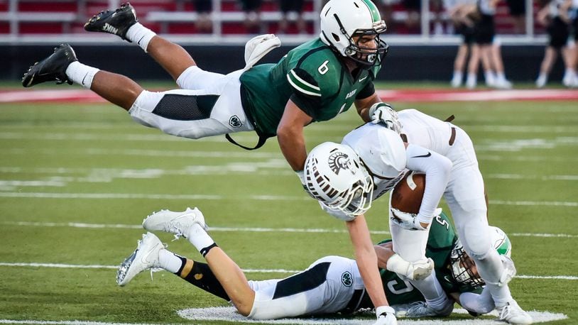 Badin’s Lavassa Martin (6) and Marshall Flaig (5) tackle Roger Bacon’s Zak Cappel during their game Sept. 22, 2017, at Fairfield Stadium. The host Rams won 41-21. NICK GRAHAM/STAFF