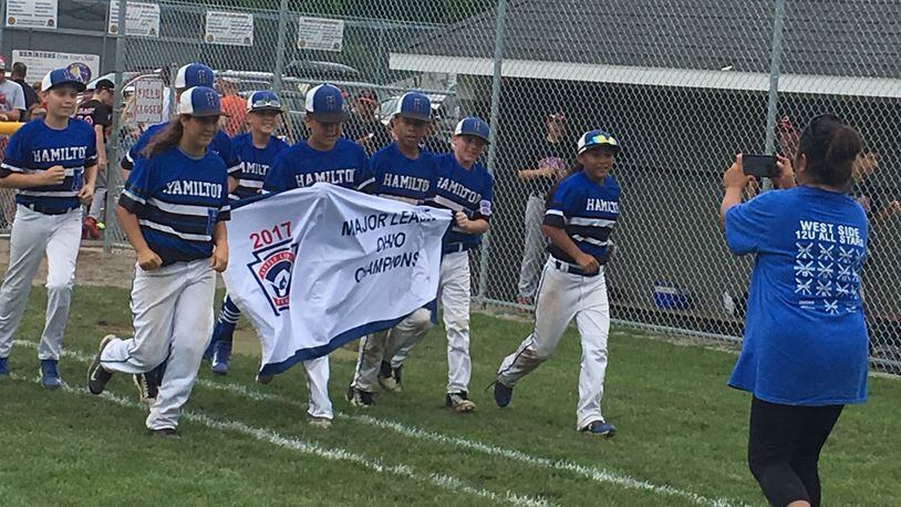 Hamilton West Side’s players do a postgame run around the field with their Ohio Little League 12-year-old baseball championship banner Saturday after defeating Canfield 15-4 at Ford Park’s Robert S. Hoag Field in Maumee. RICK CASSANO/STAFF