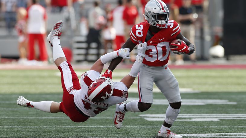 Ohio State running back Demario McCall, right, escapes the grasp of Miami (Ohio) defensive back Bart Baratti during the first half of an NCAA college football game Saturday, Sept. 21, 2019, in Columbus, Ohio. (AP Photo/Jay LaPrete)