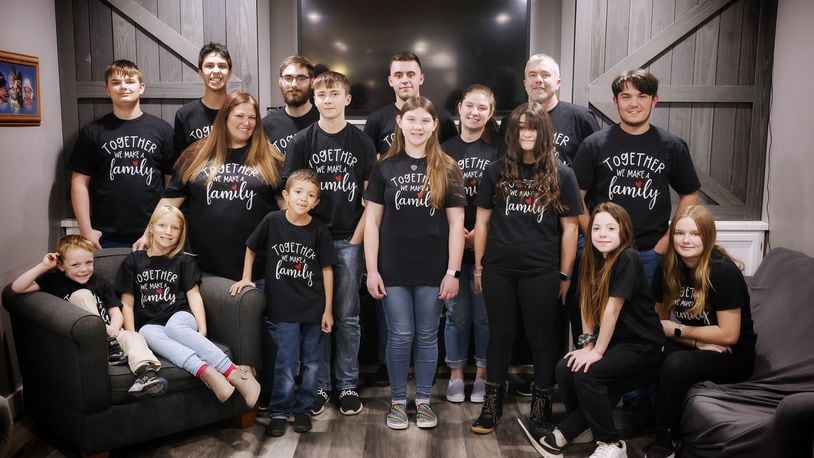 Christina and Richard Bennett are adopting two more kids on National Adoption Day bringing their total number of adoptions to seven. They stand and sit as a family in matching shirts. Back row, left to right: William, 14, Eli, 15, Austin, 23, Nathan, 20 and Richard. Middle row, left to right: Christina, Tyler, 14, Savannah, 13, McKenna, 20, Abigail, 12, and Isaiah, 15. Front row, left to right: Elijah, 6, Ashlynn, 8, Brayden, 8, Jocelynn, 10, and Samantha, 14. NICK GRAHAM/STAFF