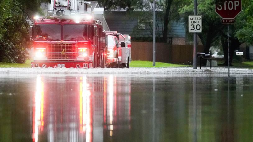 A Houston firetruck makes it way through flood water in North Woodland Hills after severe flooding, Thursday, May 2, 2024, in the Houston neighborhood of Kingwood, Texas. (Jason Fochtman/Houston Chronicle via AP)