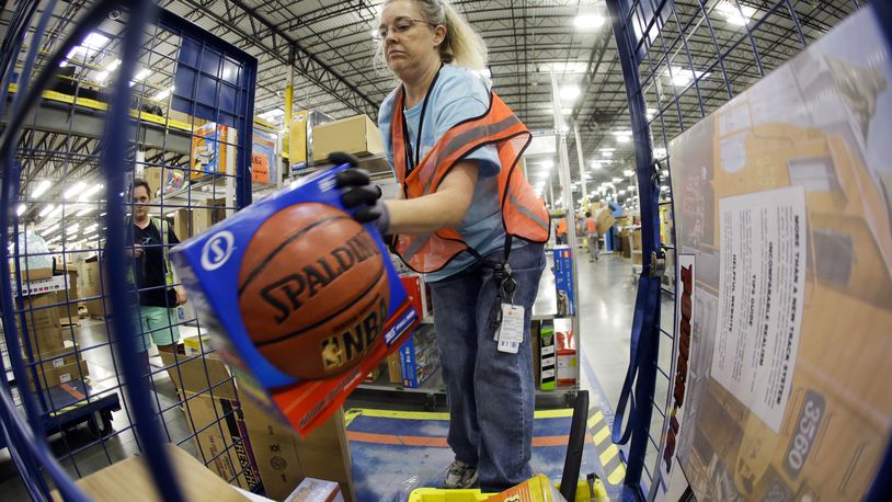In this Dec. 1, 2014 photo, Teresa Clark fills an order at the Amazon fulfillment center on Cyber Monday, in Lebanon, Tenn. Retailers have been pushing back shipping deadlines and extending free shipping offers, putting more pressure package carriers. Amazon extended its free-shipping deadline by one day to Dec. 19. (AP Photo/Mark Humphrey)