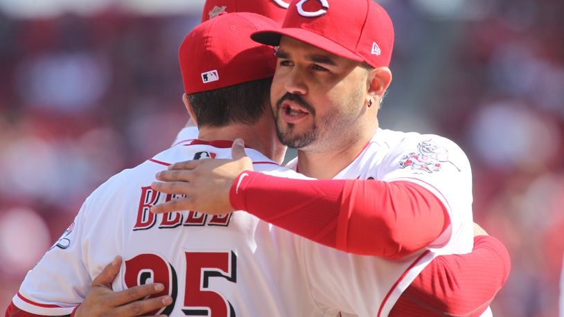 The Reds’ Eugenio Suarez hugs manager David Bell before a game against the Pirates on Opening Day on Thursday, March 28, 2019, at Great American Ball Park in Cincinnati.