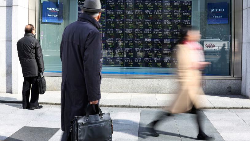 People look at an electronic stock board of a securities firm in Tokyo Monday. Asian shares opened sharply lower Monday, extending global stock losses after Wall Street’s big selloff. AP Photo/Koji Sasahara)