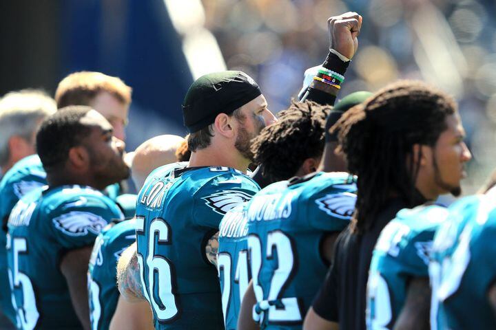 nfl players stand, kneel and raise fists