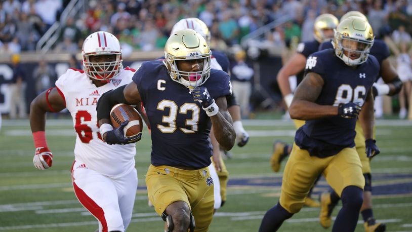 Notre Dame running back Josh Adams (33) heads for the end zone in front of Miami’s A.J. Burdine during Saturday night’s 52-17 Fighting Irish victory at Notre Dame Stadium in Notre Dame, Ind. CHARLES REX ARBOGAST/ASSOCIATED PRESS