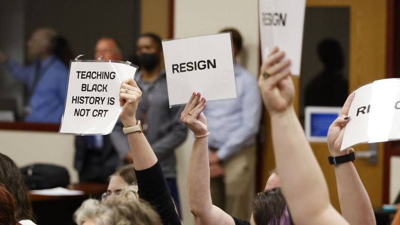 Attendees hold up signs during the Lakota Board of Education meeting that lasted over three hours in May 2022. Lakota’s school board is considering a new public speaking policy for its meetings as the latest in a series of procedural changes in response to periodic contentiousness during its meetings. NICK GRAHAM/STAFF