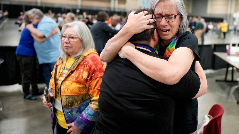 Angie Cox, left, and Joelle Henneman hug after an approval vote at the United Methodist Church General Conference Wednesday, May 1, 2024, in Charlotte, N.C. United Methodist delegates repealed their church’s longstanding ban on LGBTQ clergy with no debate on Wednesday, removing a rule forbidding “self-avowed practicing homosexuals” from being ordained or appointed as ministers.(AP Photo/Chris Carlson)