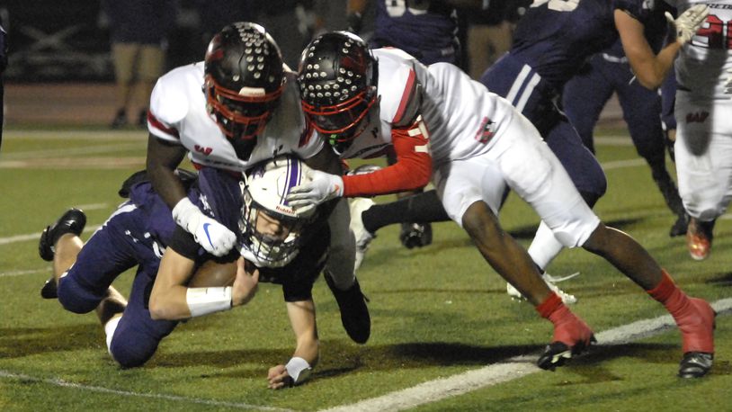 Lakota West's Cole Munday, 79, and Taebron Bennie-Powell, 3, tackle an Elder ball carrier during the second quarter of a Division I Regional Semifinal game at Princeton on Friday, Nov. 11. DAVID A. MOODIE/CONTRIBUTING PHOTOGRAPHER