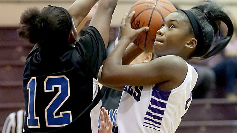 Middletown guard Sa’Mill Calhoun draws a foul from Miamisburg’s Aliyah Burks during their game at Wade E. Miller Gym in Middletown on Nov. 26, 2016. COX MEDIA FILE PHOTO