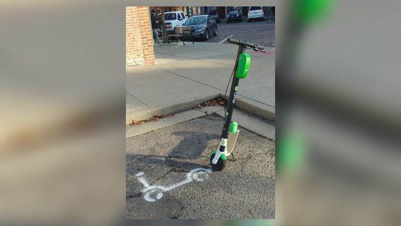 A Lime electric scooter rests next to the scooter logo in the parking space on East Park Place which is one of two Uptown reserved for eScooters and eBikes in the Uptown area. CONTRIBUTED/BOB RATTERMAN