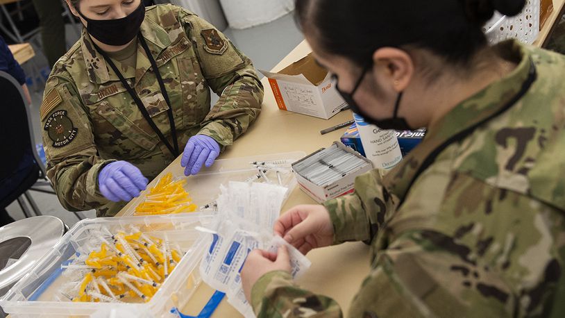 Airmen assemble syringes for use in distribution of the COVID-19 vaccine inside the pharmacy area of community vaccination center at Ford Field in Detroit on May 3. U.S. AIR FORCE PHOTO/WESLEY FARNSWORTH