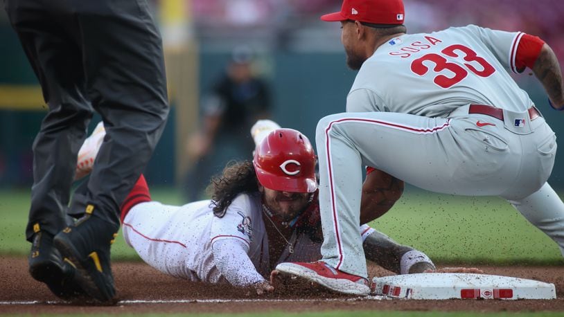 Jonathan India, of the Reds, slides into third against Edmundo Sosa, of the Phillies, on Thursday, April 13, 2023, at Great American Ball Park in Cincinnati. The throw from the catcher got past Sosa, and India scored. David Jablonski/Staff
