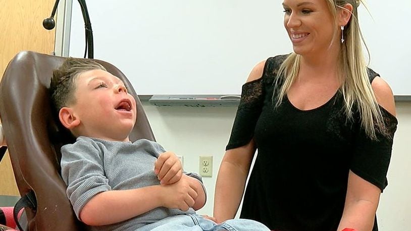 Remington Willman and his mother, Melanie, smile as he enjoys his new mini-car. The car, which was custom-made for him by Lakota East students, is a stylish alternative to a motorized wheelchair and will allow him to play and socialize more easily. WCPO