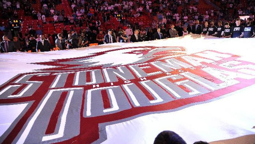 A large banner in memory of the victims of the Marjory Stoneman Douglas High School shooting is unfurled before an NBA basketball game in Miami on Saturday, Feb. 24, 2018, between the Miami Heat and the Memphis Grizzlies. (AP Photo/Gaston De Cardenas)