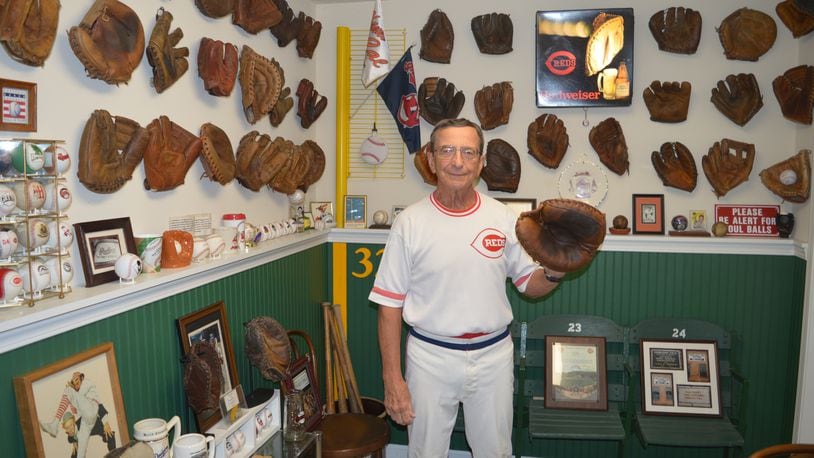 Ron Zemko poses wearing a catcher’s mitt in the “glove room” of his basement. His baseball glove collection has outgrown that room, however and some of his 245 gloves are displayed on the floor against the wall of other parts of the basement. CONTRIBUTED/BOB RATTERMAN