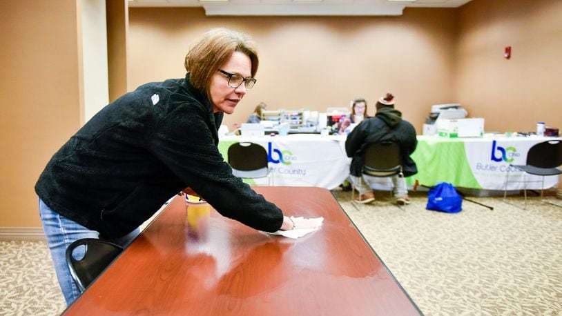 Janette Prater, a unit support worker with Butler County Job and Family Services, wipes tables with a disinfecting cloth between visitors Thursday. Butler County Job and Family Services and Child Support Enforcement Agency have set up a makeshift office in a conference room on the ground floor of the Government Services Center in Hamilton to help ease access for those in need of help during the coronavirus (COVID-19) outbreak. They are sanitizing tables, keyboards, telephones, pens and other items frequently to help minimize risk of spreading germs. NICK GRAHAM/STAFF