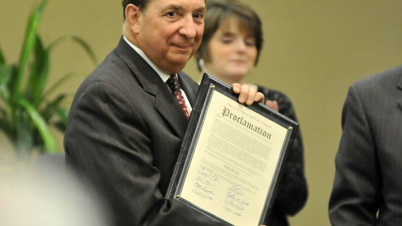In this 2015 photo, former Fairfield City Manager Art Pizzano holds a proclamation from Mayor Steve Miller and City Council in honor of his retirement. MICHAEL D. PITMAN/STAFF