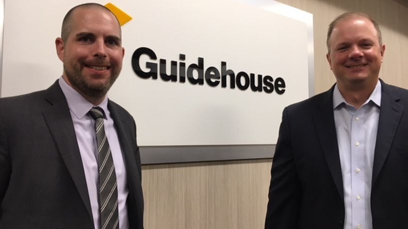 Justin Lambert (left), a management consultant at Guidehouse’s Beavercreek office, and Jim Ebel, the partner at the office. THOMAS GNAU/STAFF