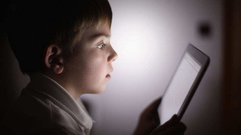 In this photograph illustration, a 10-year-old boy uses an Apple Ipad tablet computer. CHRISTOPHER FURLONG/GETTY IMAGES