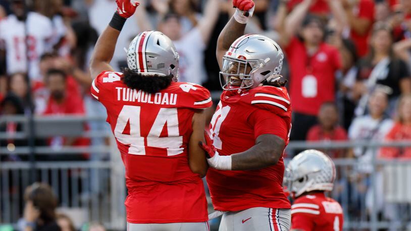 Ohio State defensive lineman Tyleik Williams, right, celebrates his fumble recovery and touchdown against Western Kentucky with teammate J.T. Tuimoloau during the second half of an NCAA college football game, Saturday, Sept. 16, 2023, in Columbus, Ohio. (AP Photo/Jay LaPrete)