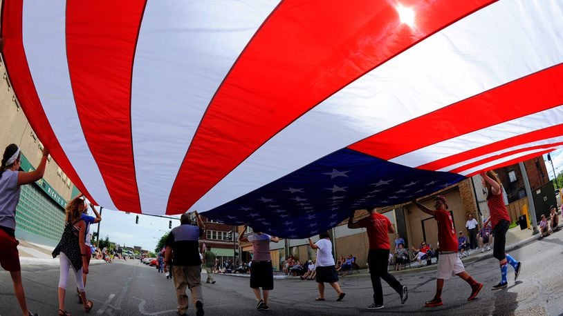 A group carries a large American flag during the Broad Street Blast Independence Day parade Saturday, July 2 in Middletown. NICK GRAHAM/STAFF