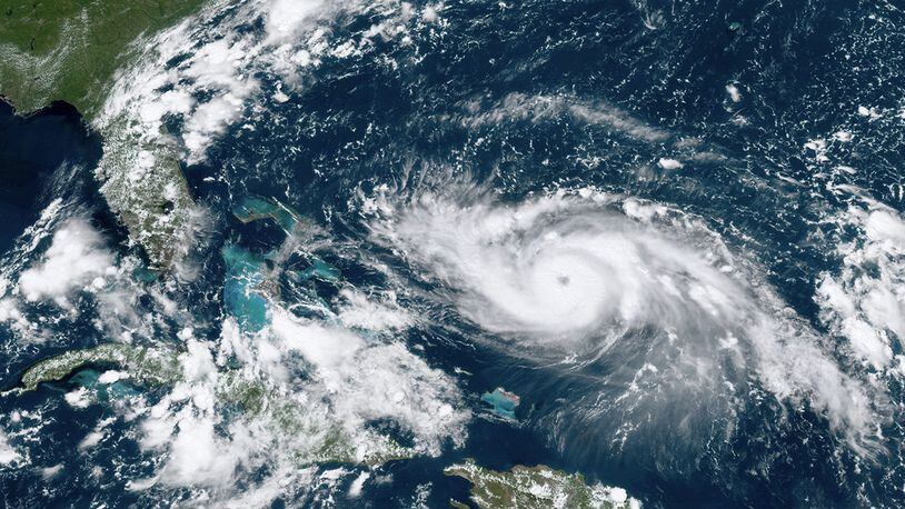 This GOES-16 satellite image taken Friday, Aug. 30, 2019, at 17:20 UTC and provided by National Oceanic and Atmospheric Administration (NOAA), shows Hurricane Dorian, right, moving over open waters in the Atlantic Ocean.