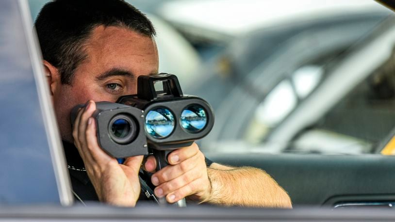 New Miami Police Officer Mark Bennett uses their Lidar photo laser speed enforcement camera along US 127 Wednesday, Nov. 30 in New Miami. A court hearing regarding the old freestanding speed cameras previously used by New Miami is scheduled for Dec. 1. NICK GRAHAM/STAFF