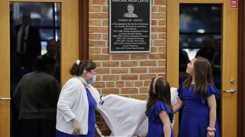 The media center at Hamilton High School was renamed the Thomas A. Alf Memorial Media Center in memory of Alf, who served as teacher, administrator school board member and more for the Hamilton school district. Alf's daughter, Katie Poe, left, and granddaughters Helen Burk, 5, middle, and Ella Burk, 8, unveiled the plaque. NICK GRAHAM/STAFF