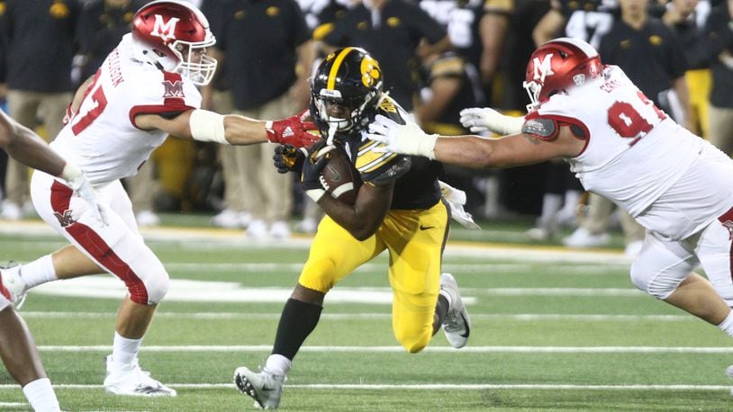 IOWA CITY, IOWA- AUGUST 31: Running back Tyler Goodson #15 of the Iowa Hawkeyes rushes up field during the second half between defensive lineman Austin Ertl #92 and Will Kellison #97 of the Miami Ohio RedHawks on August 31, 2019 at Kinnick Stadium in Iowa City, Iowa. (Photo by Matthew Holst/Getty Images)