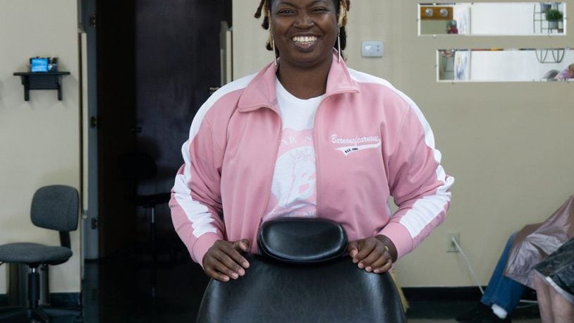 Juiquetta Harmon, who cuts hair under the name KiKi the Barber, stands behind the chair in her South Locust Street shop. JARRED WATKINS/CONTRIBUTED