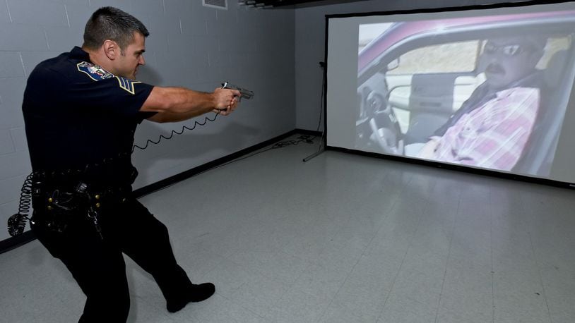 In this 2015 photo, Sergeant Chris Whitton with West Chester Twp. Police Department demonstrates a training simulator used for threat assessment and decision making training in high stress environments. The simulator has a debrief function to allow the officer to explain the actions taken and show where and if the target was hit if the gun was discharged. The Fairfield Police Department plans to also begin using a similar simulator to train police officers. NICK GRAHAM/STAFF
