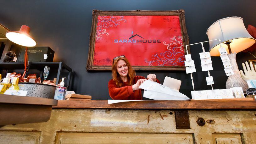 Sara Vallandingham, owner of Saraâ€™s House in downtown Hamilton, packs up an online order for shipment Wednesday, March 18, 2020. With decreased foot traffic in the store she is trying other ways to serve her customers like shipping orders through her online store and curb-side pickup. NICK GRAHAM / STAFF