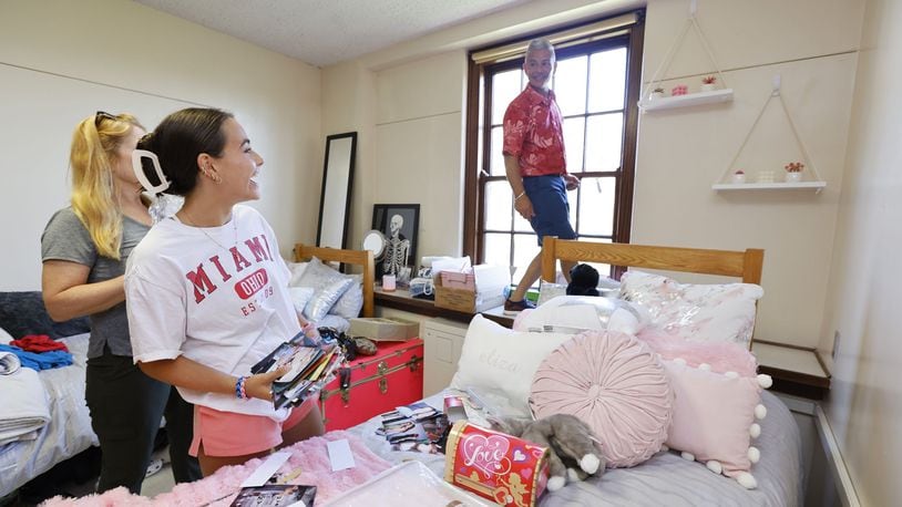 Eliza Rivera, from New York, gets help from her dad, David Rivera, hanging decorations in her dorm room on move in day at Miami University in Oxford Thursday, Aug. 18, 2022. NICK GRAHAM/STAFF