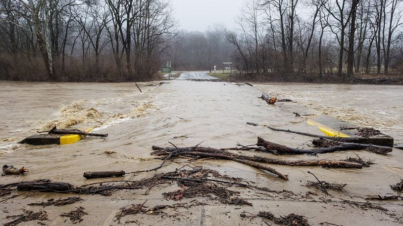 Water from Elk Creek washes over the bridge at Elk Creek MetroPark Sebald Park Area Wednesday after heavy rain overnight in the area. The park, part of Butler county MetroParks, is closed due to the high water. NICK GRAHAM/STAFF