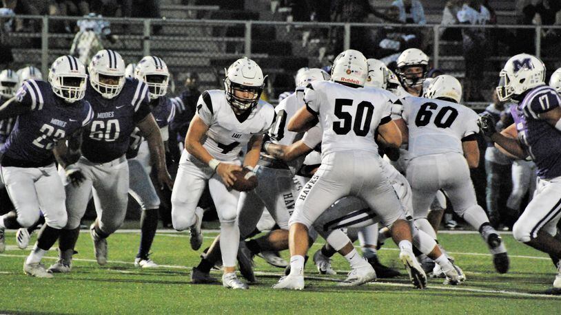 Lakota East quarterback Sean Church (4) gets some blocking help from Sam Florence (50) as Middletown’s Ty Johnson (23), Javen Davis (60) and Kenny Wilson (17) are in pursuit in a game earlier this season at Barnitz Stadium in Middletown. East won 32-7. CONTRIBUTED PHOTO BY OLIVER SANDERS