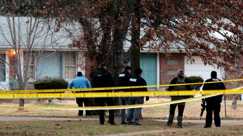 Police officers work the scene where two St. Louis County officers were shot and a man barricaded himself inside a home on Thursday, Dec. 14, 2017, in the St. Louis County town of Bellefontaine Neighbors, Mo. Officers are trying to negotiate his surrender. (Robert Cohen/St. Louis Post-Dispatch via AP)
