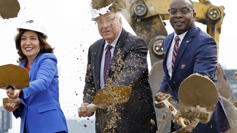 FILE - New York Gov. Kathy Hochul, left, Buffalo Bills owner Terry Pegula and Buffalo Mayor Byron Brown, right, participate in the groundbreaking ceremony at the site of the new Bills Stadium in Orchard Park, N.Y., June 5, 2023. Terry and Kim Pegula are exploring the possibility of selling a non-controlling, minority interest in the franchise, the team announced Friday, April 19, 2024. The prospect of selling shares of the Bills comes at a time the franchise is facing a cash crunch with rising construction costs of the team’s new stadium. (AP Photo/Jeffrey T. Barnes, File)