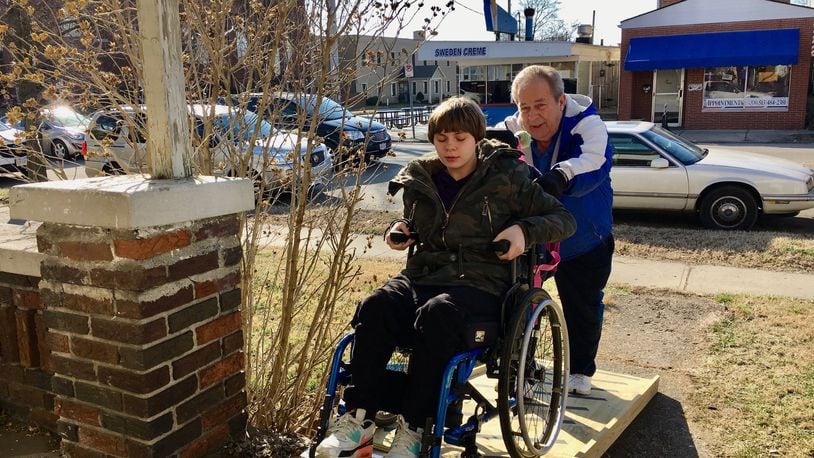 Veteran Hamilton Schools bus driver Bob Thacker pushes special needs student Katelynn Uhl up the access ramp Thacker built for her after helping her off his bus at the end of the school day. After watching Uhl and her mother fall and suffer injuries last month while struggling to get Katelynn’s wheel chair down the stairs, Thacker says he had to act. (Photo By Michael D. Clark/Journal-News)