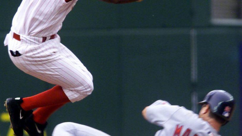 Gookie Dawkins jumps over Tino Martinez as the Reds try to complete a double play. DDN FILE